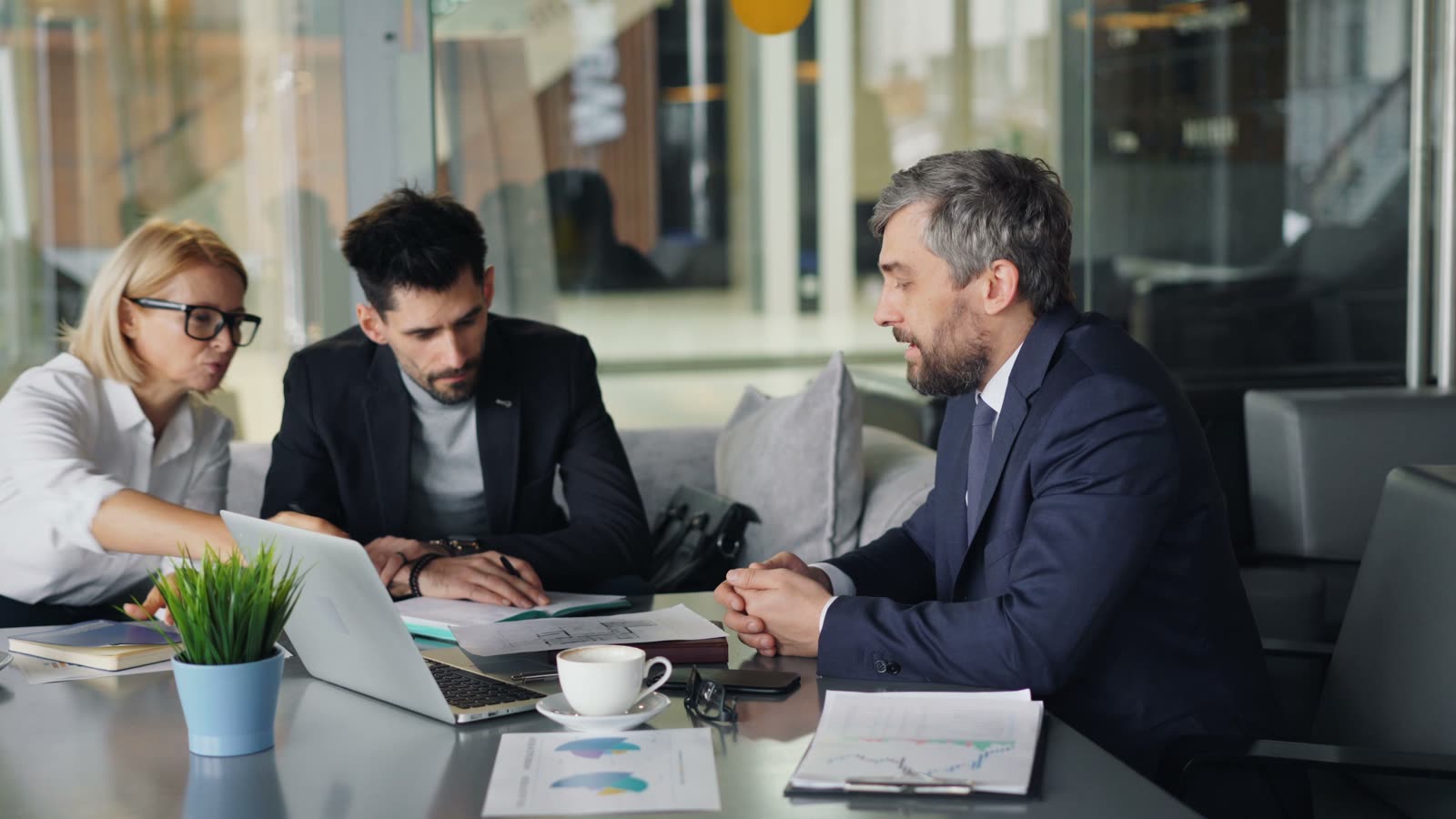 A professional working through a project with clients at a desk