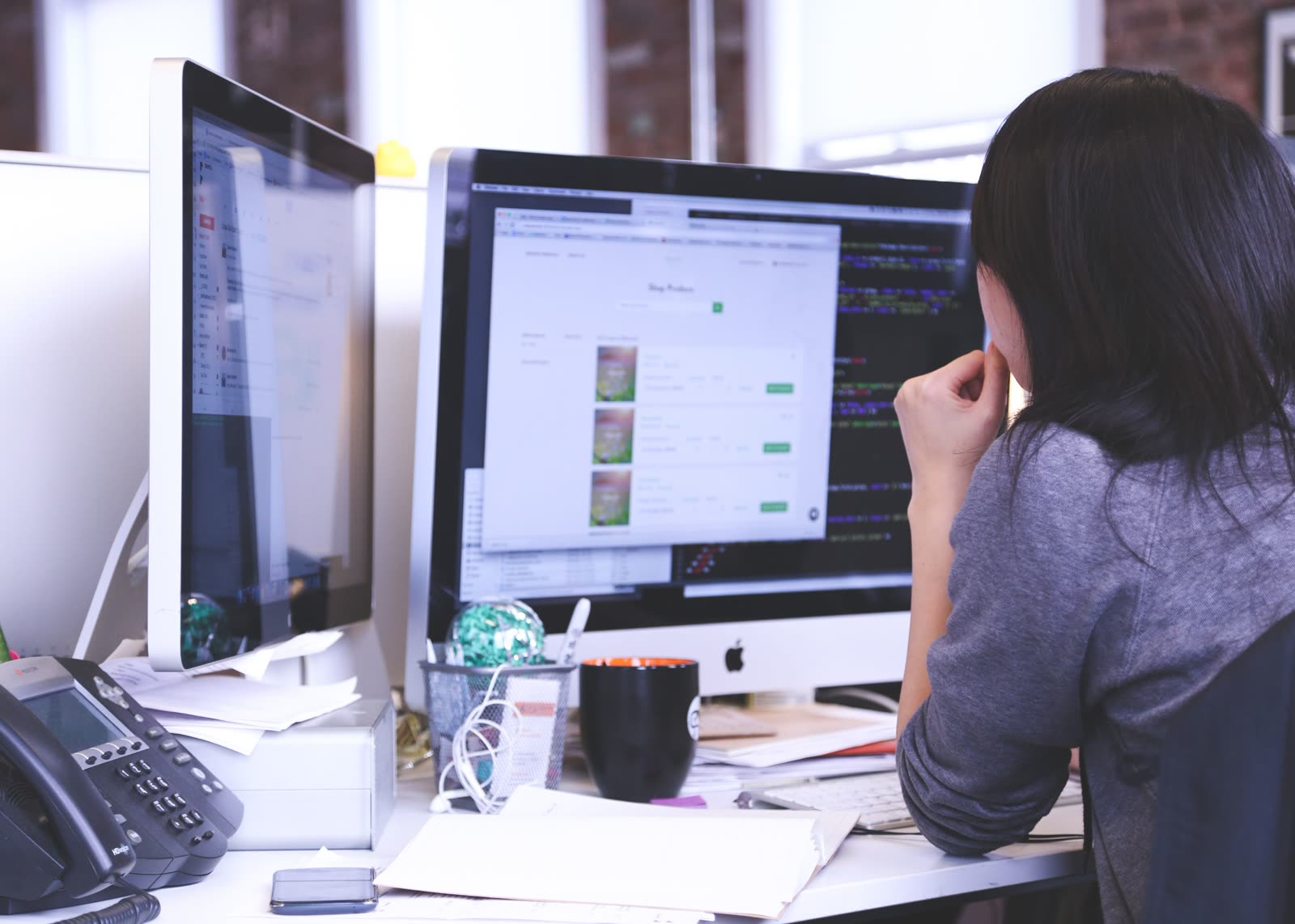 A technical professional staring at a screen, hesitating with hand near mouth